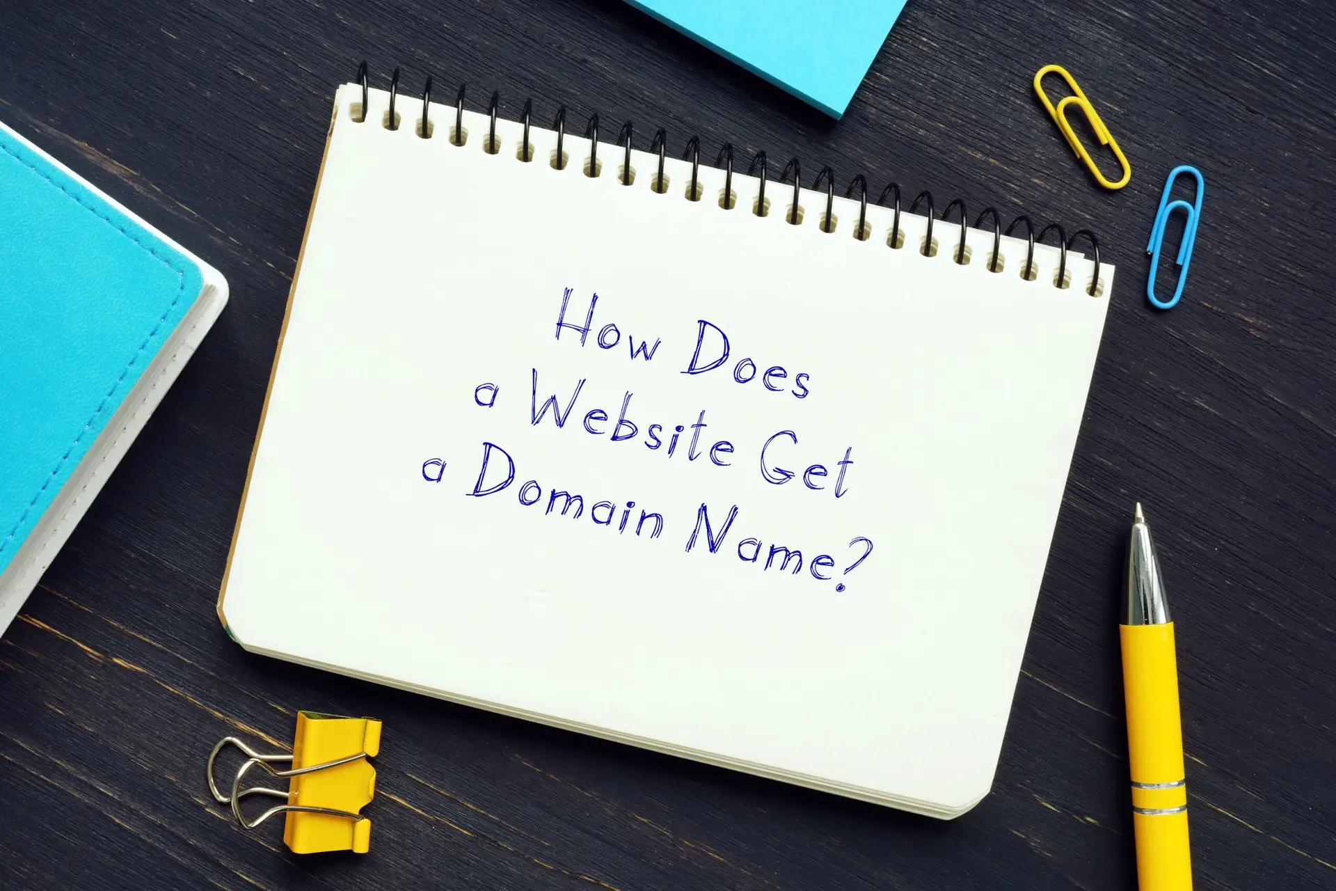 Notepad with the question how does a website get a domain name, symbolizing the process of buying a domain name